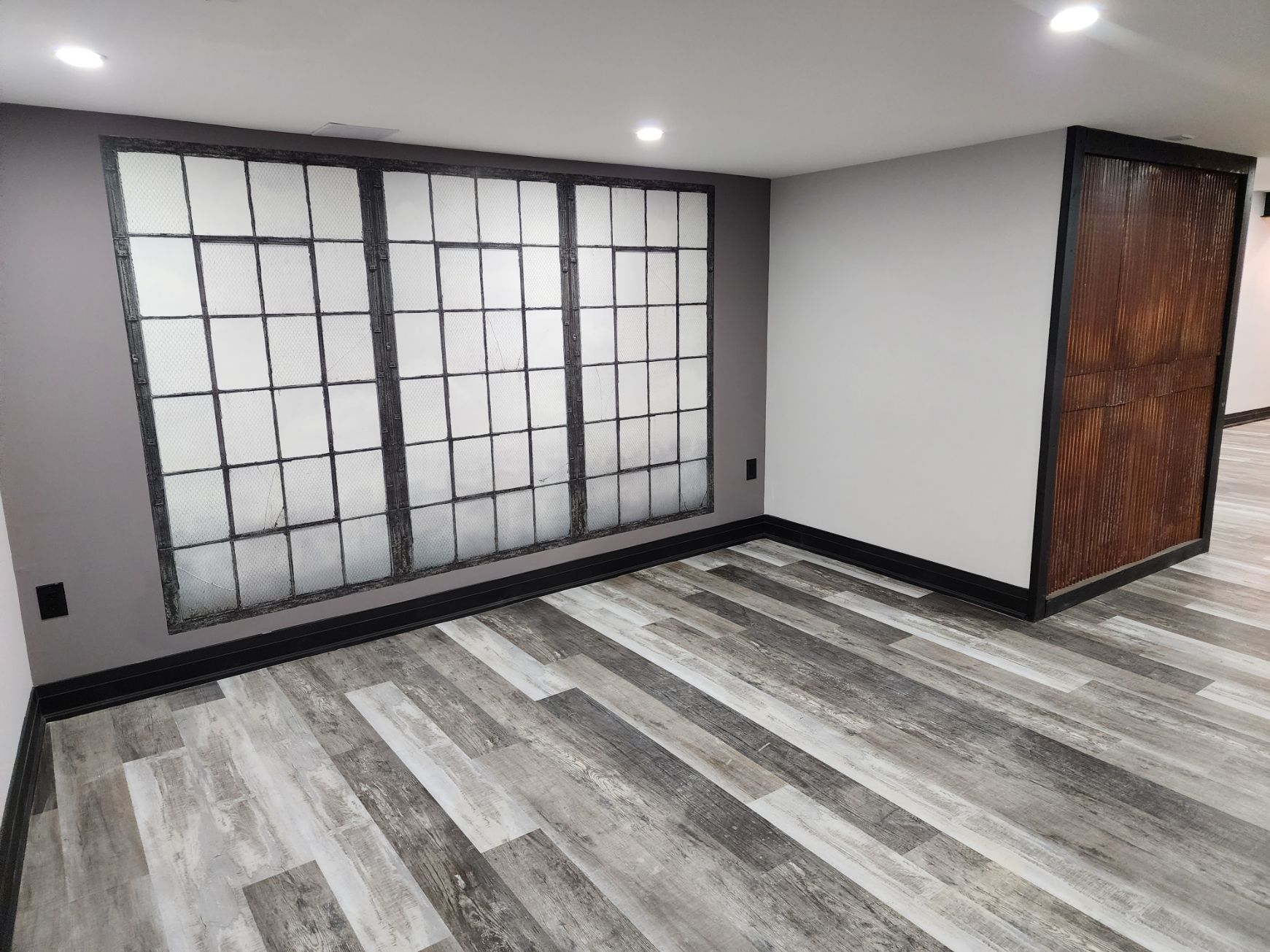 A room with a wooden floor and a large window.