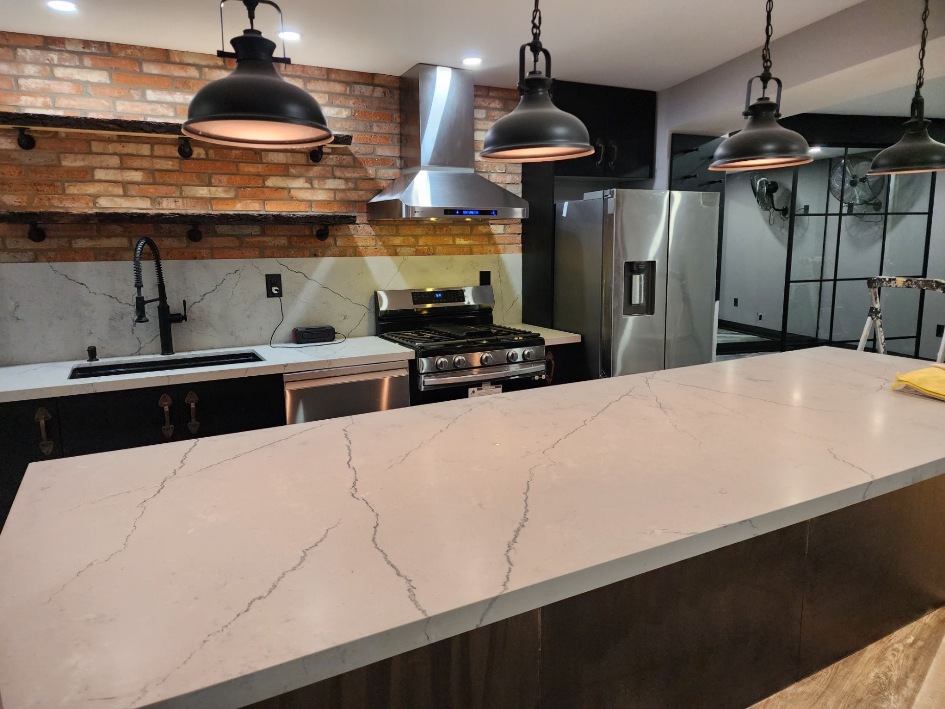 A kitchen with stainless steel appliances and a large counter top