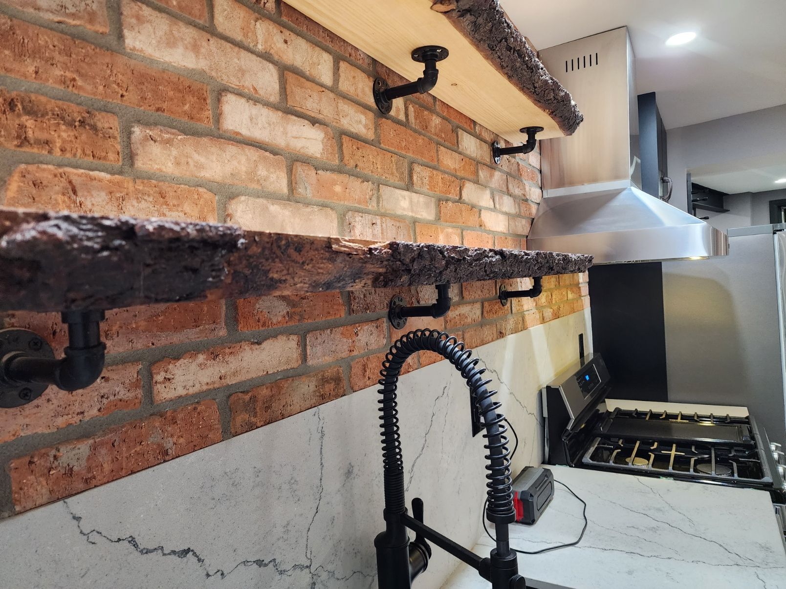 A kitchen with a brick wall and a sink