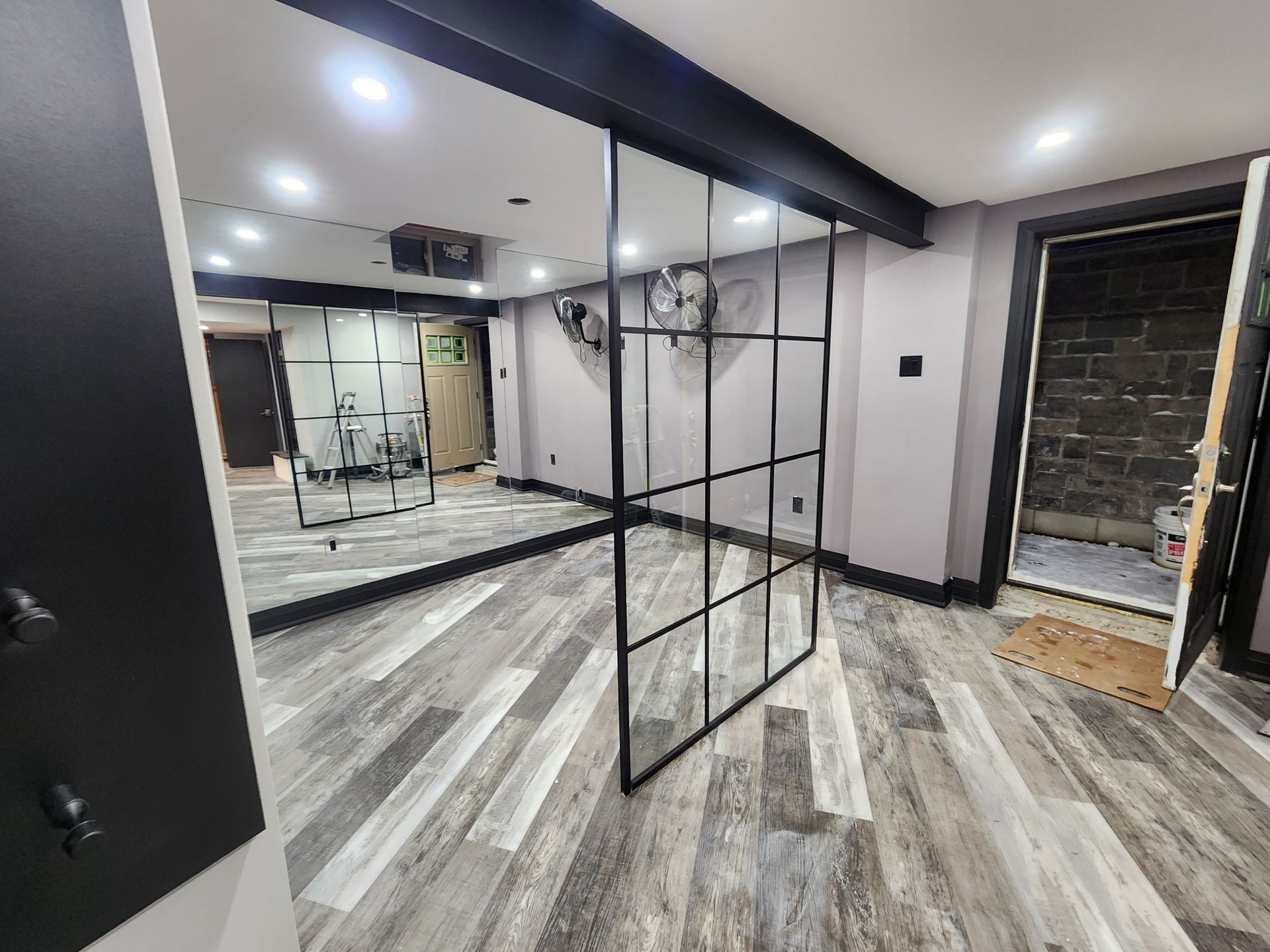 A room with a lot of mirrors and a clock on the wall.