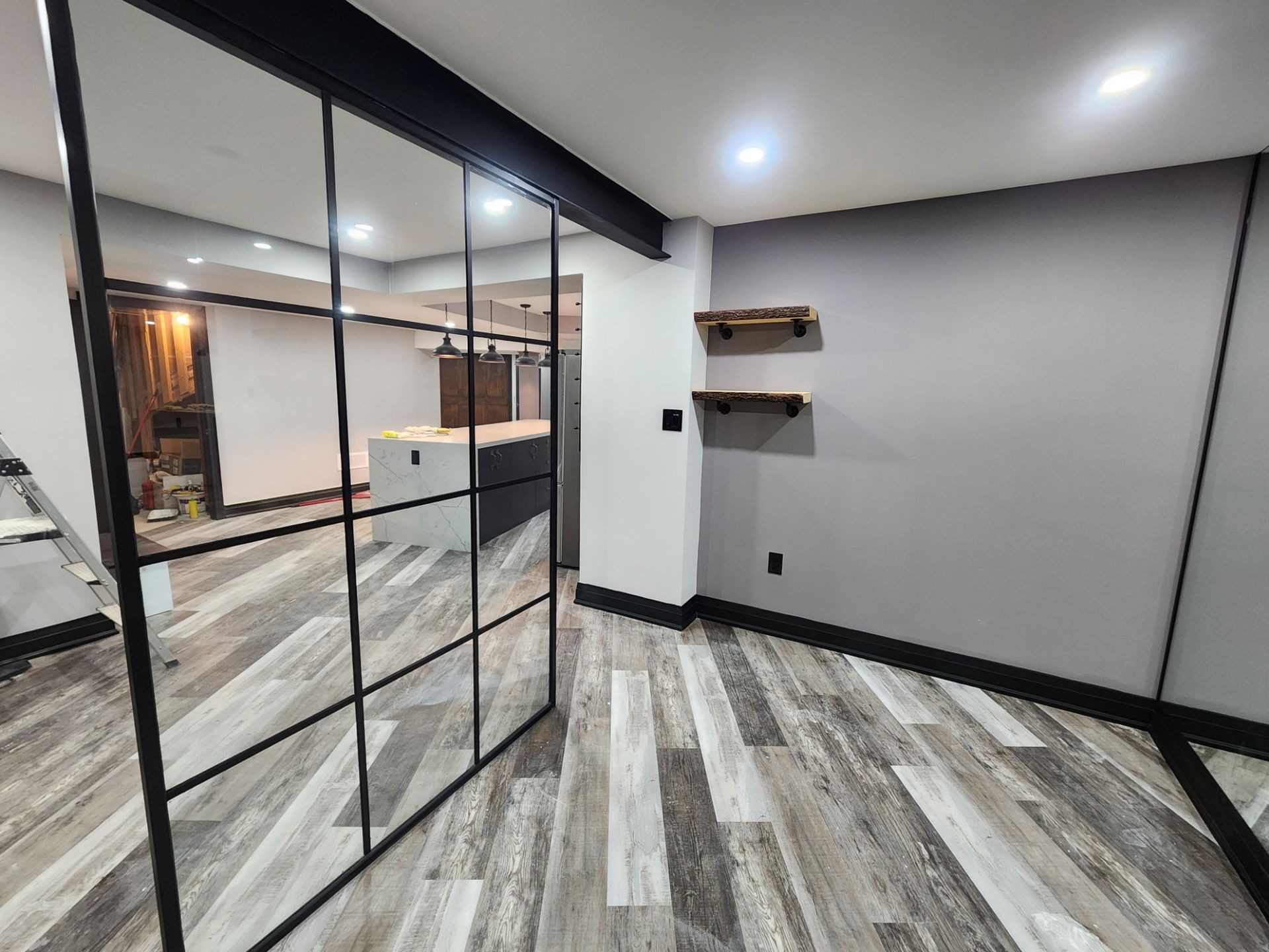 A room with a lot of mirrors on the wall and a wooden floor.