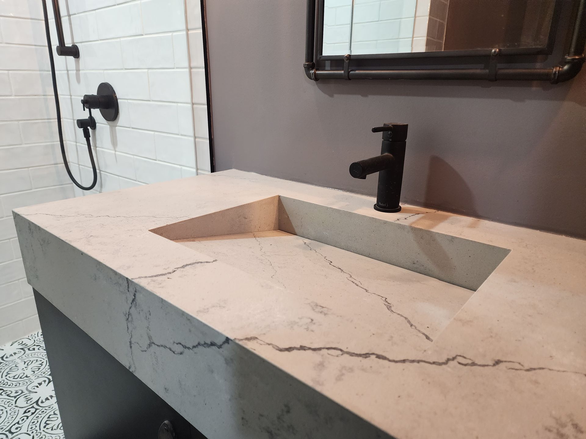A bathroom sink with a black faucet and a mirror.
