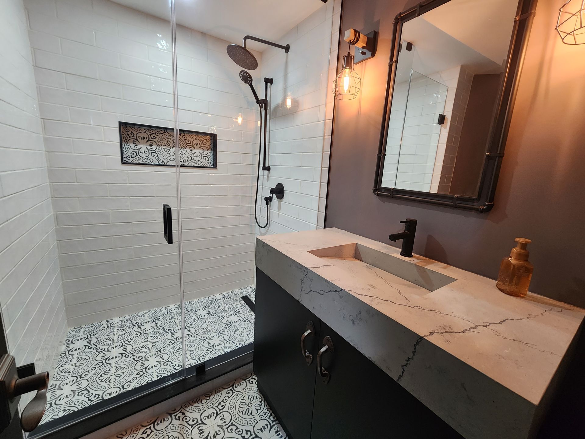 A bathroom with a walk in shower , sink and mirror.