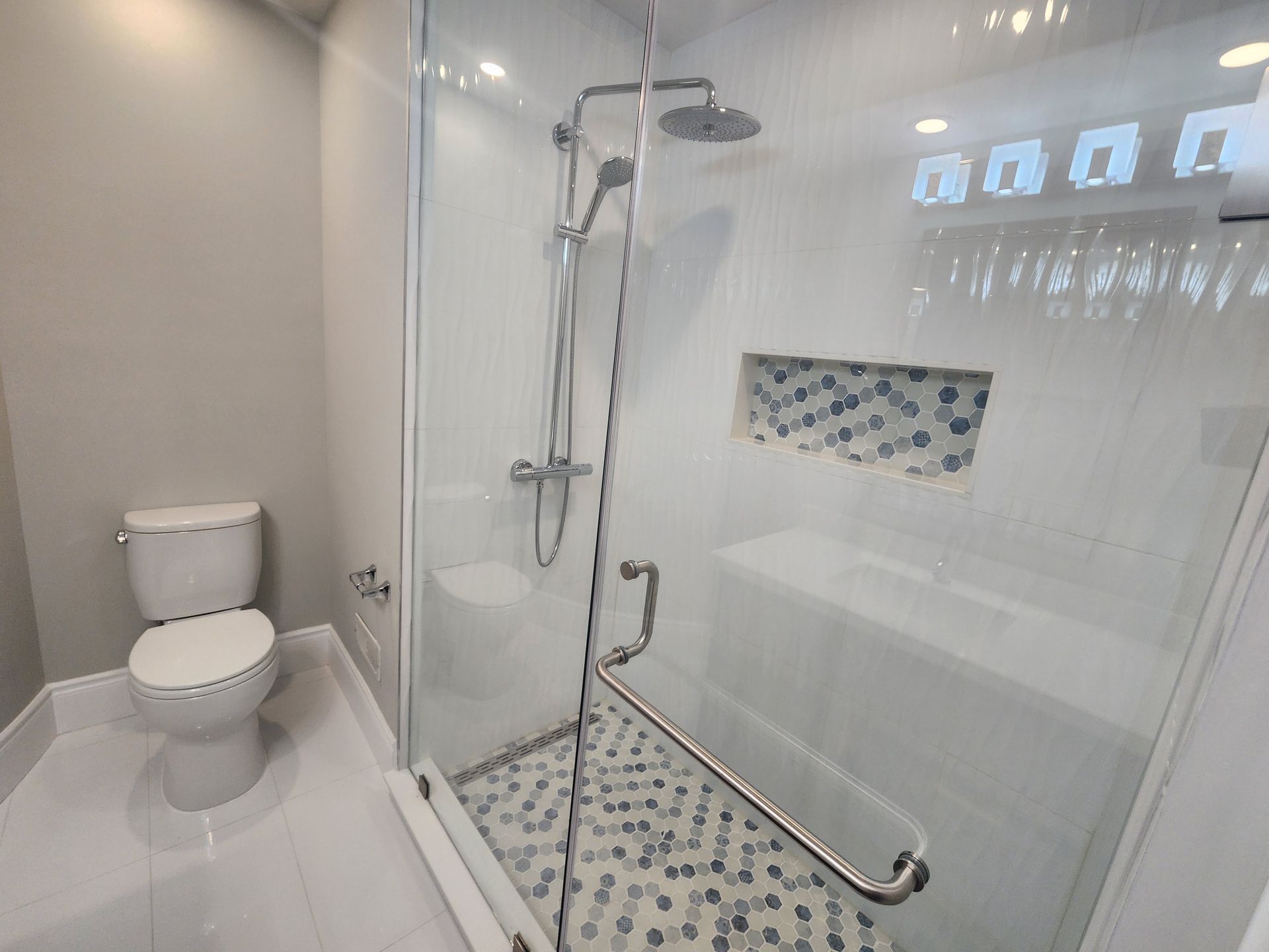 A bathroom with a toilet , shower and bathtub.