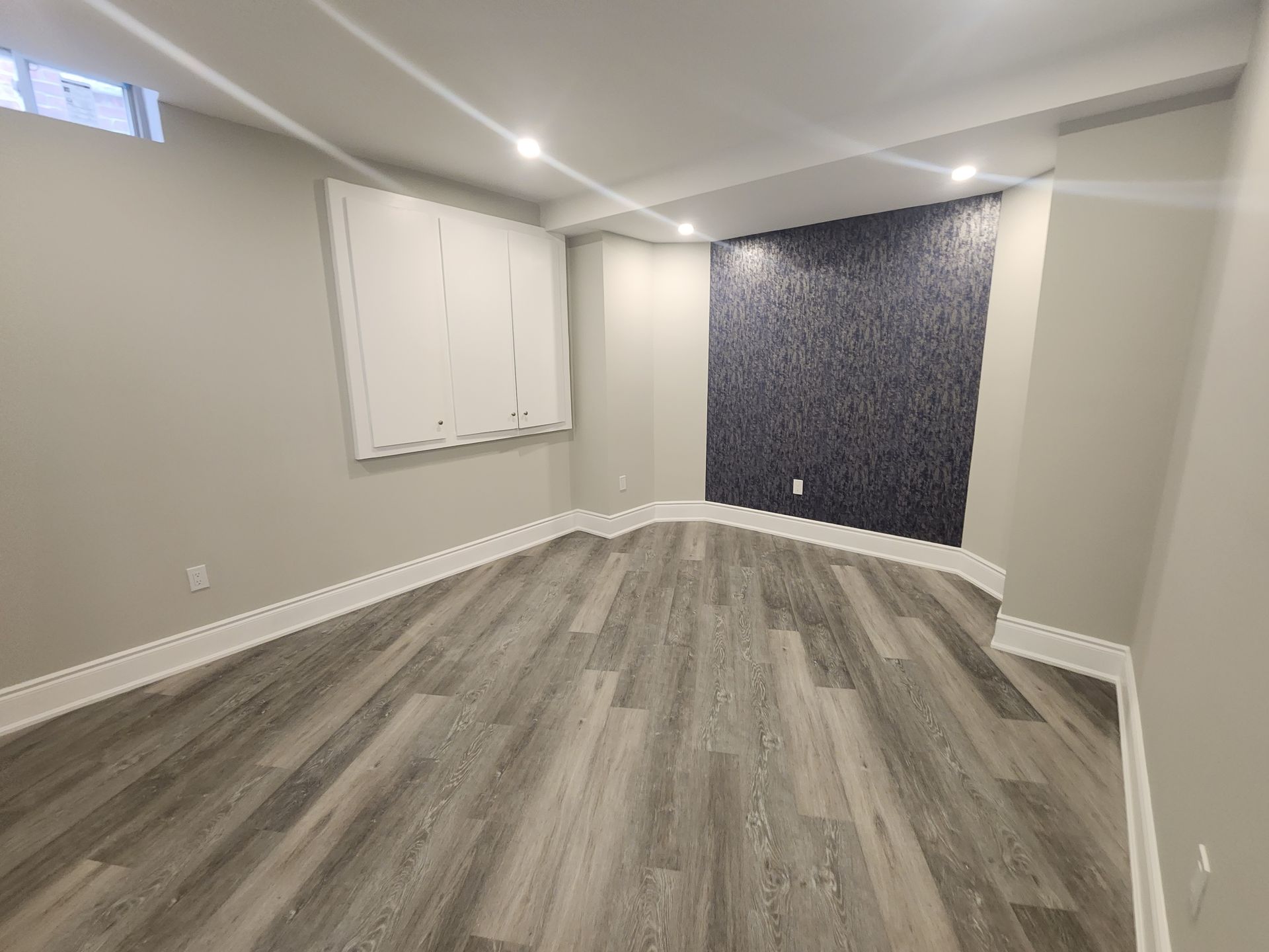 An empty room with a wooden floor and a window.