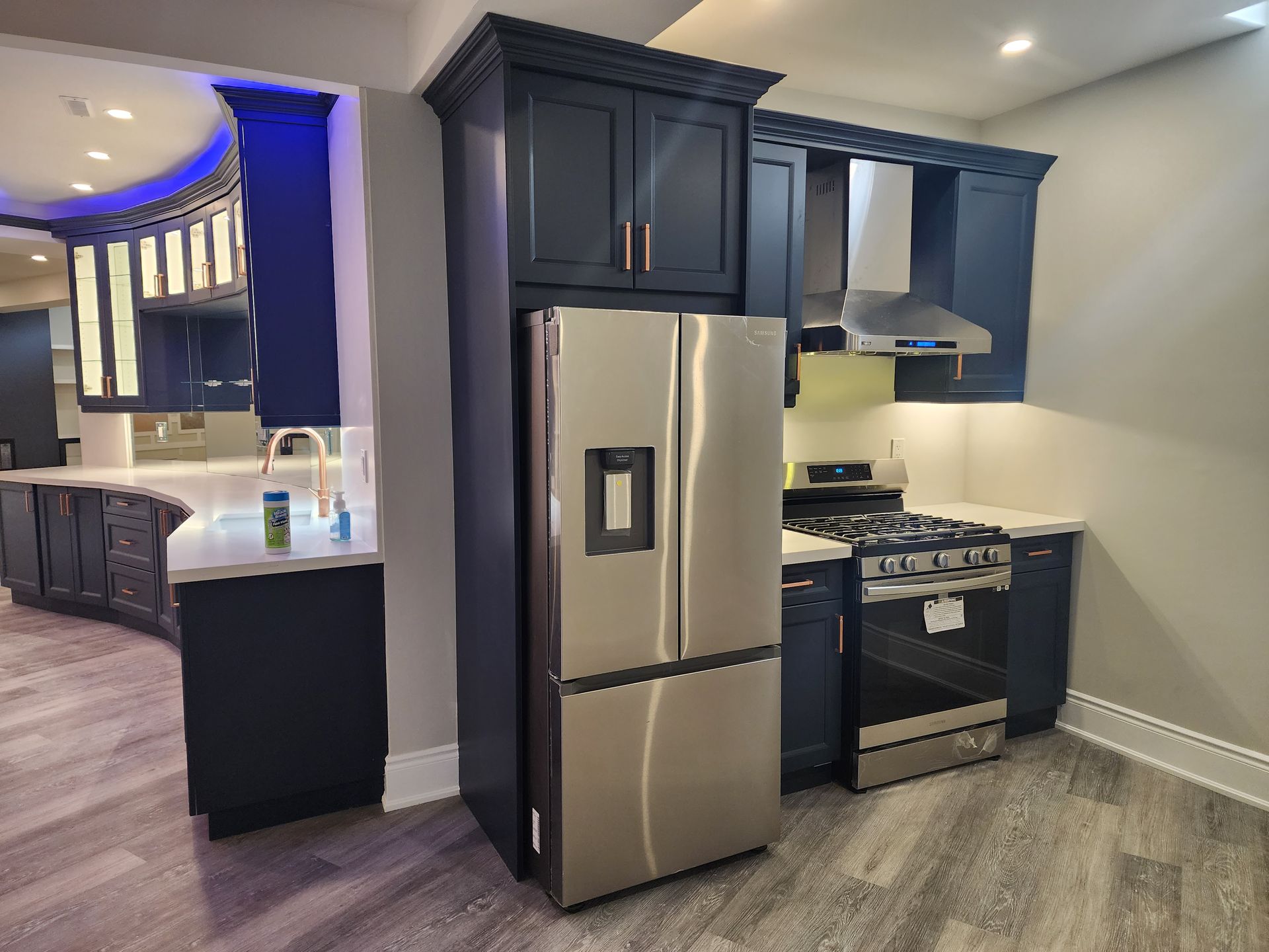 A kitchen with stainless steel appliances and blue cabinets.