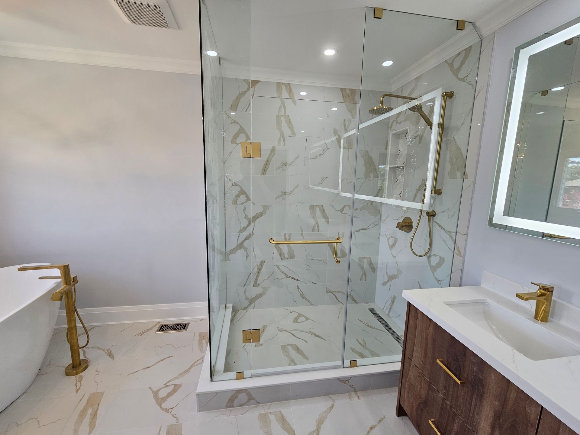 A bathroom with a walk in shower , sink , and mirror.