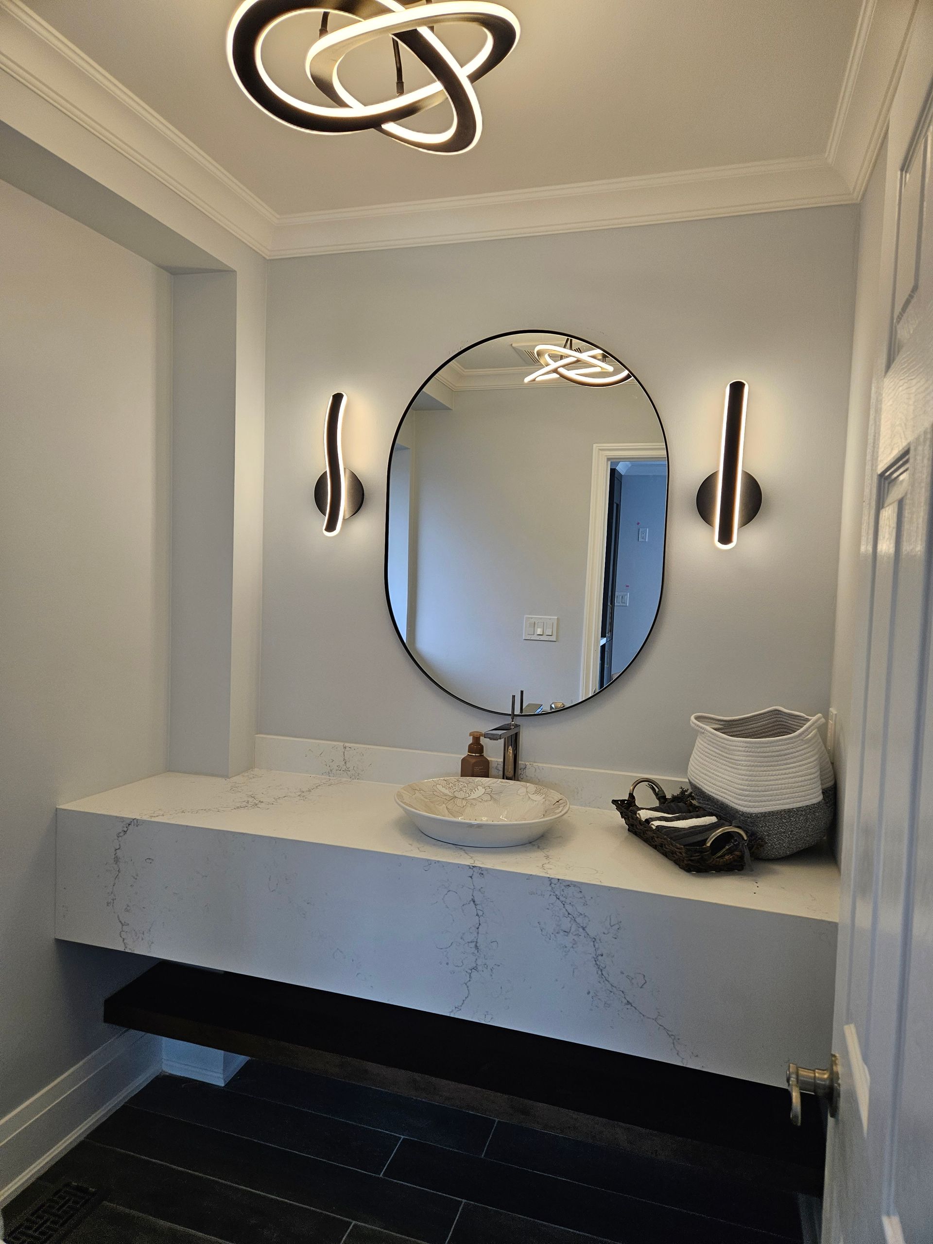 A bathroom with a sink and a round mirror