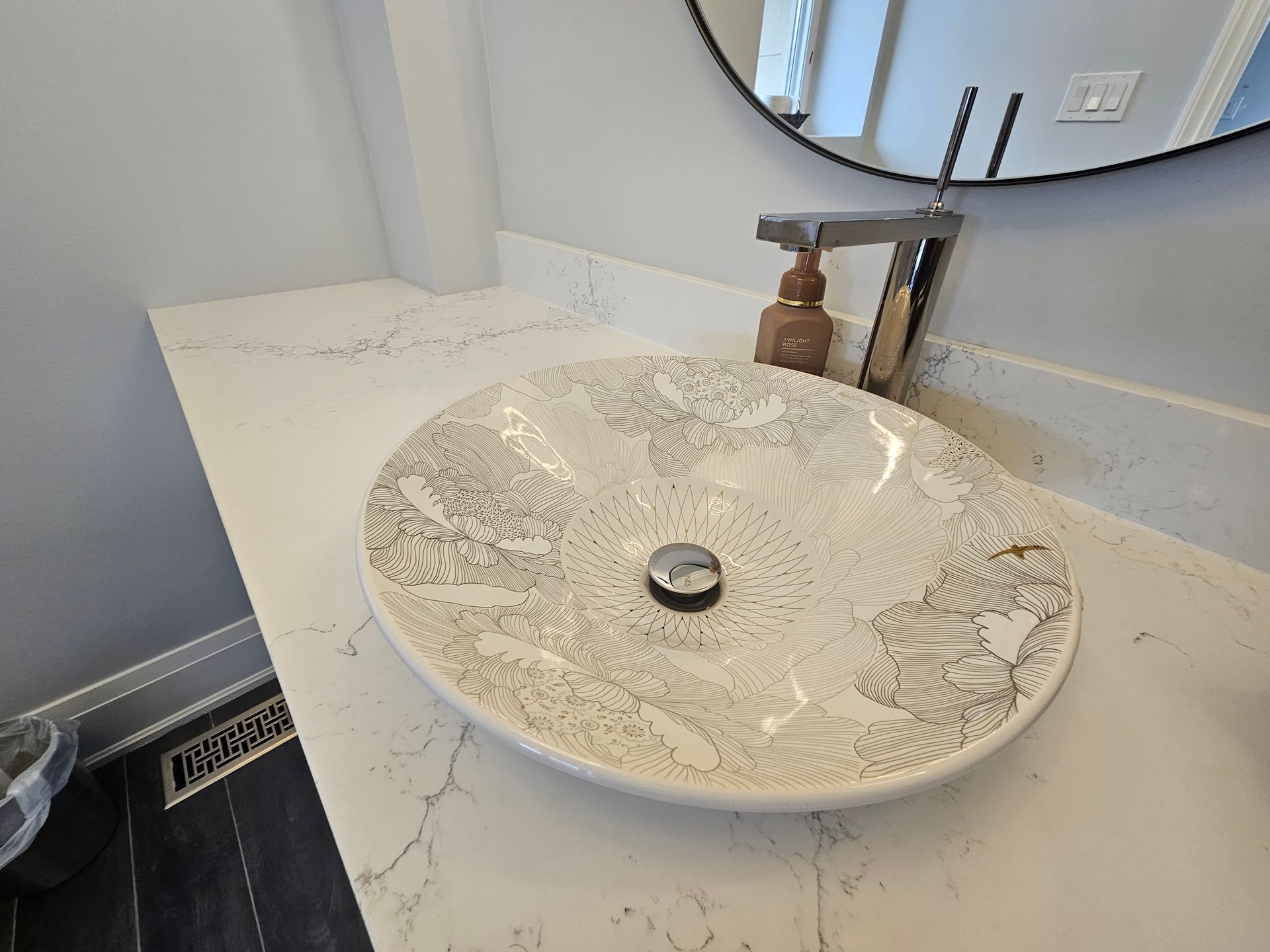 A bathroom sink is sitting on top of a white counter.