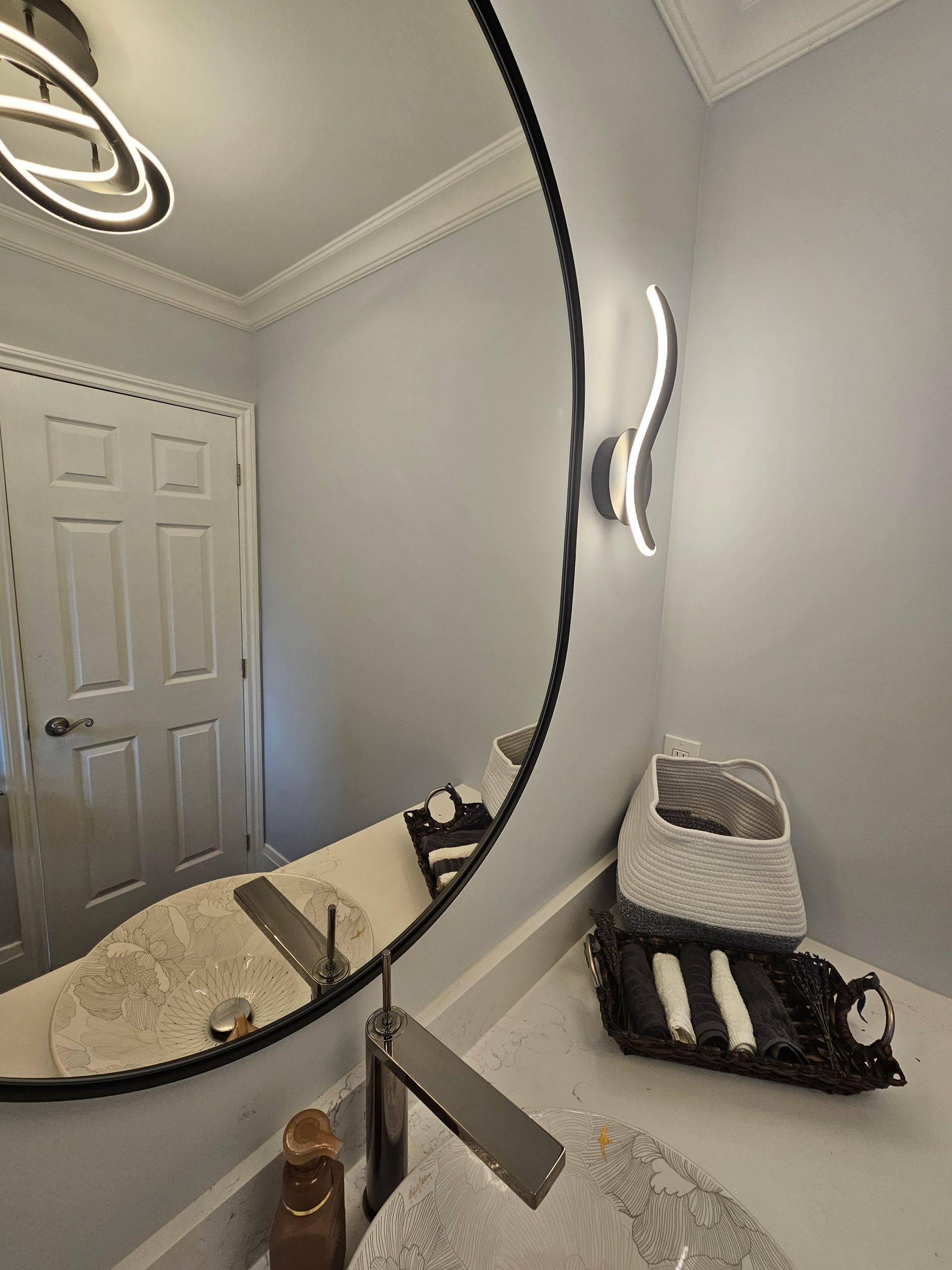 A bathroom with a large round mirror and a sink.