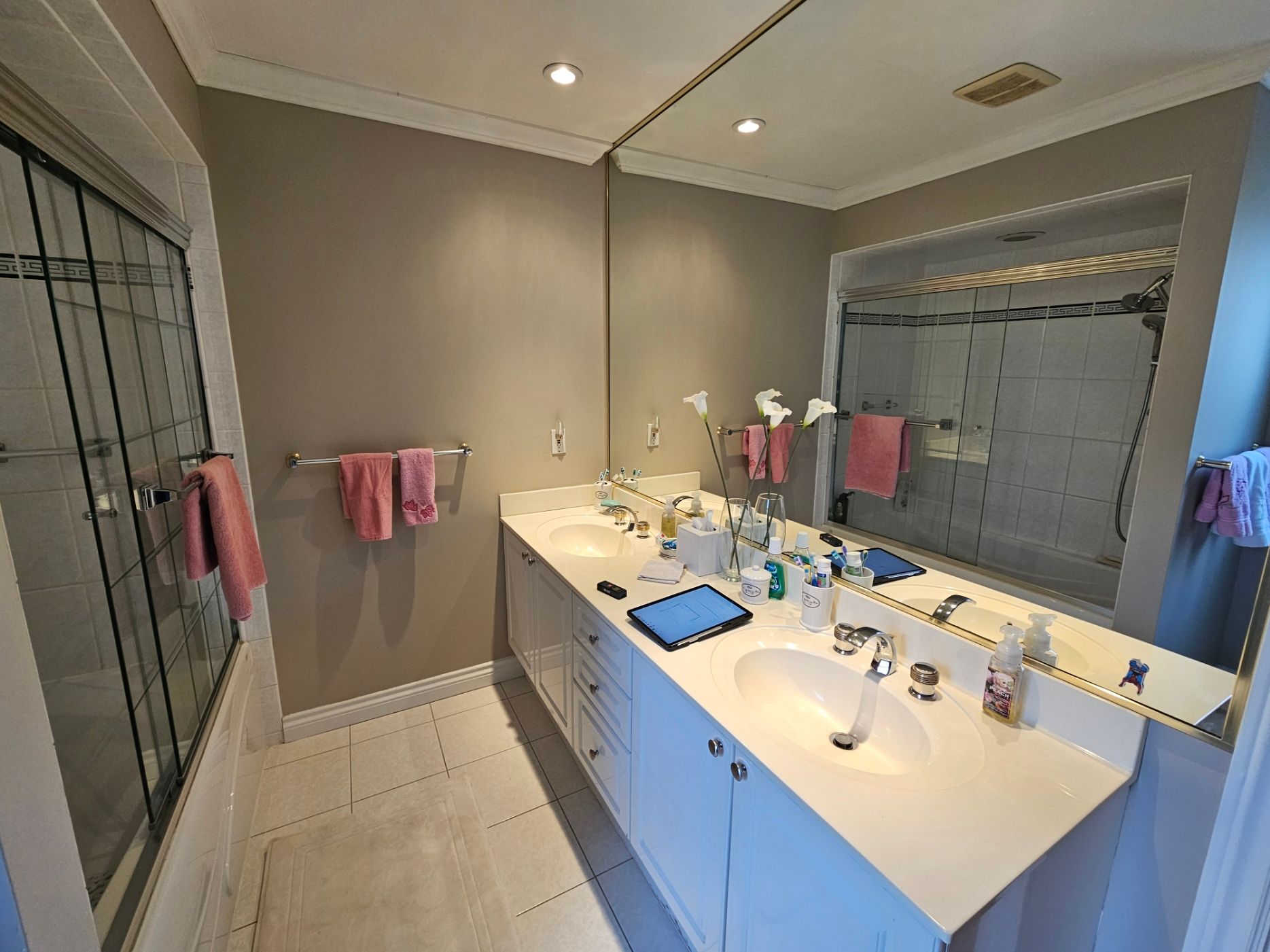 A bathroom with two sinks and a large mirror.