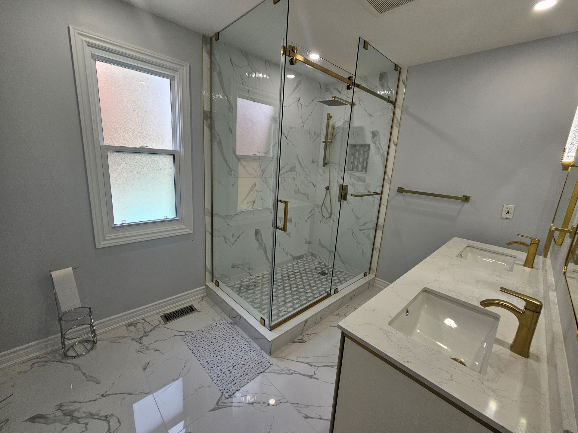 A bathroom with a walk in shower and two sinks.