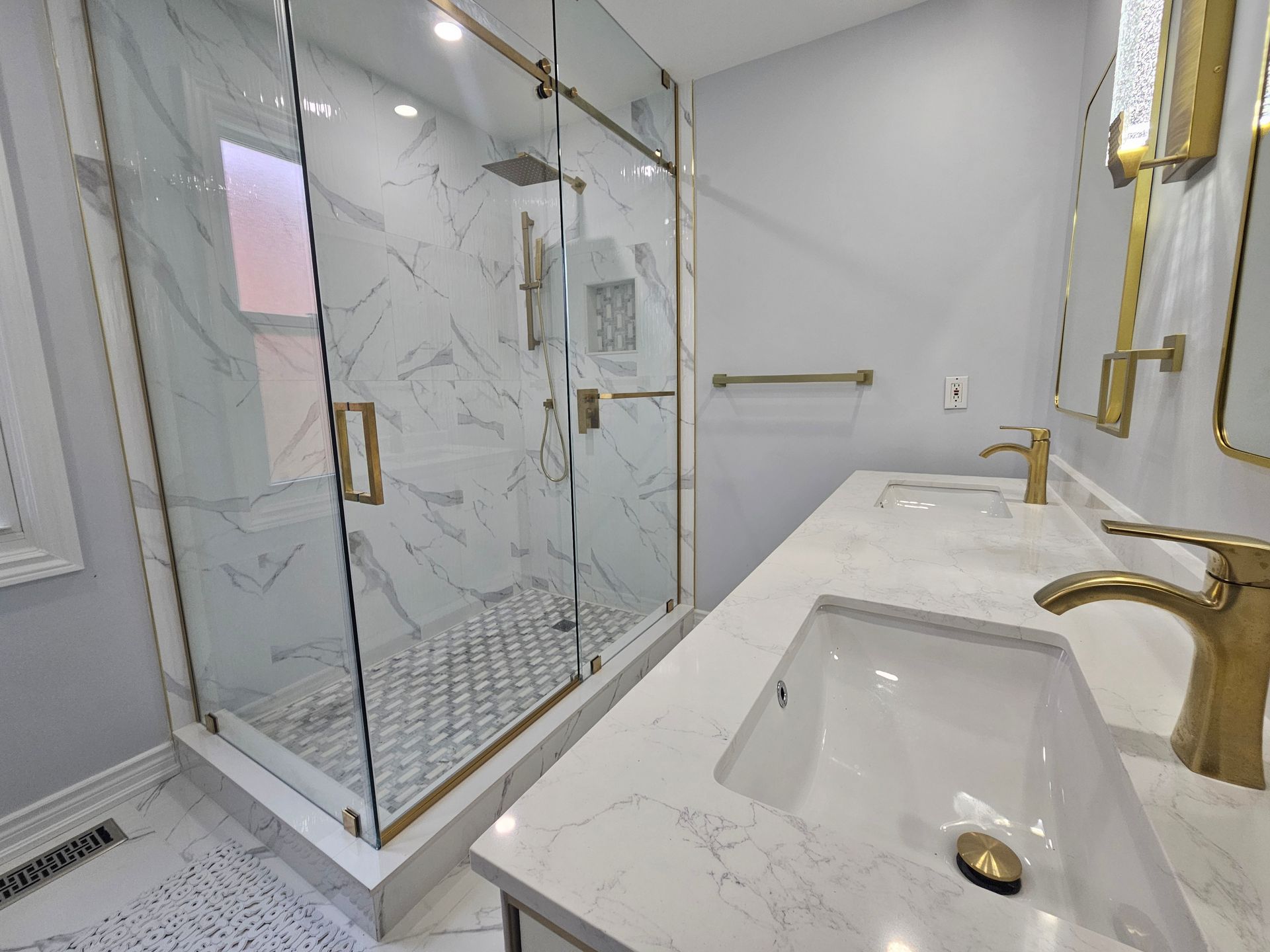 A bathroom with two sinks and a walk in shower.