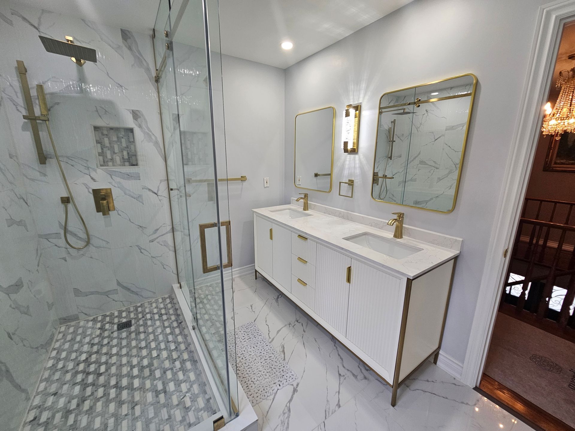 A bathroom with a walk in shower , sink and mirrors.