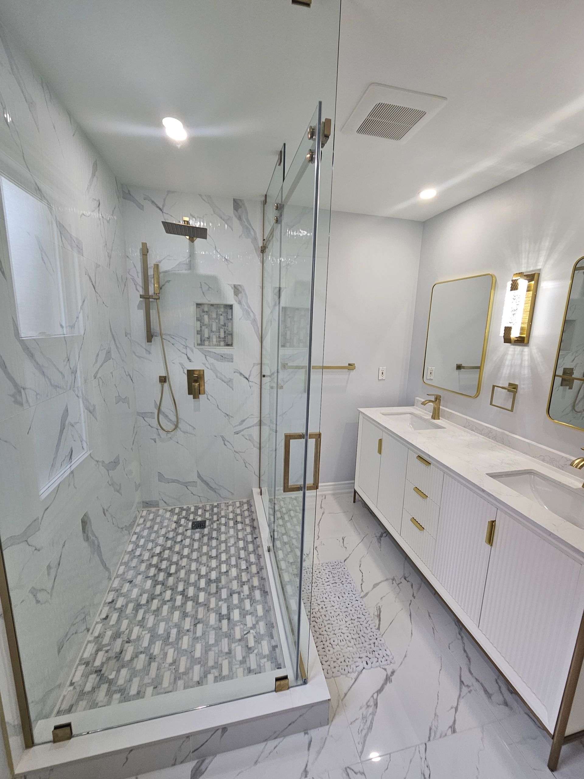 A bathroom with a walk in shower , sink and mirror.