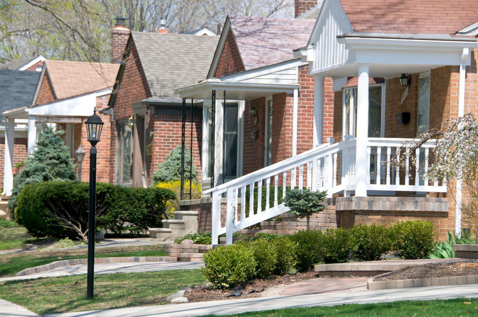A row of brick houses with white porches and stairs