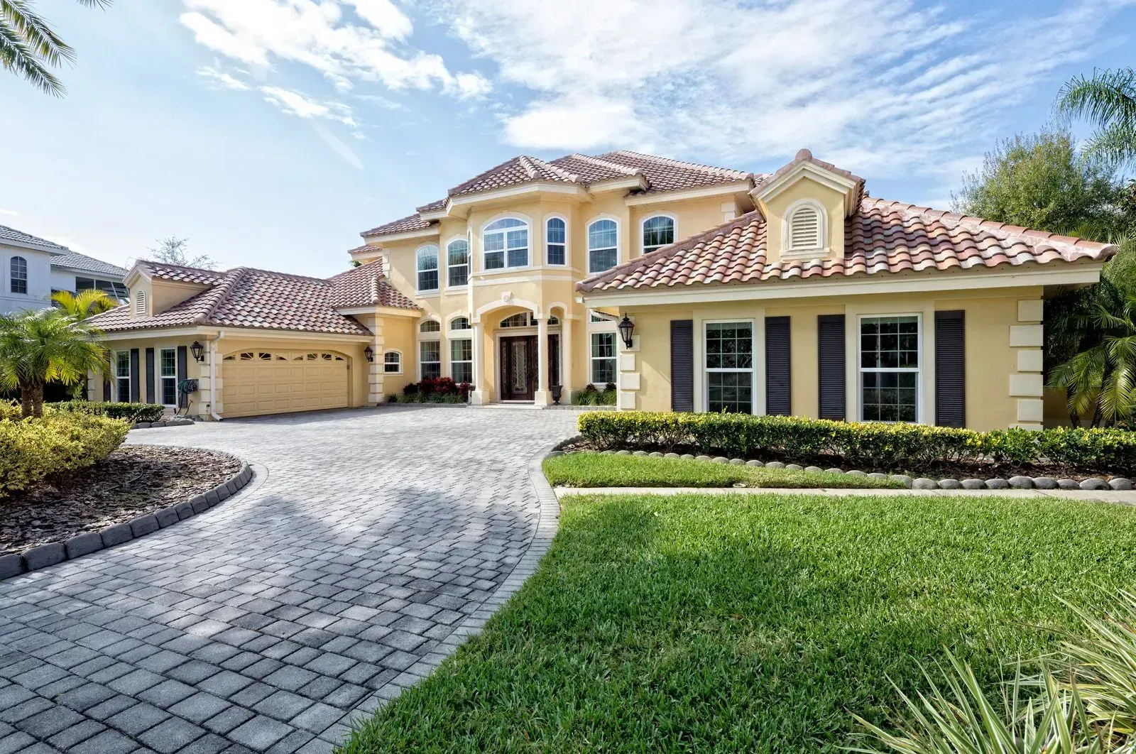 A large house with a brick driveway leading to it