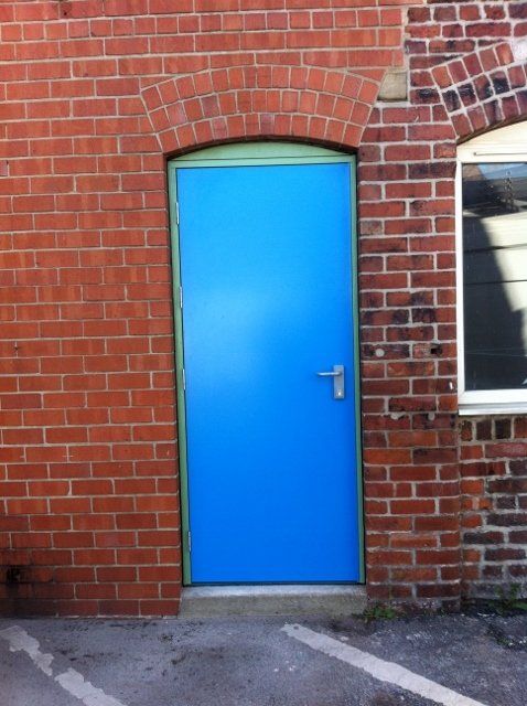 A blue door on a red brick building