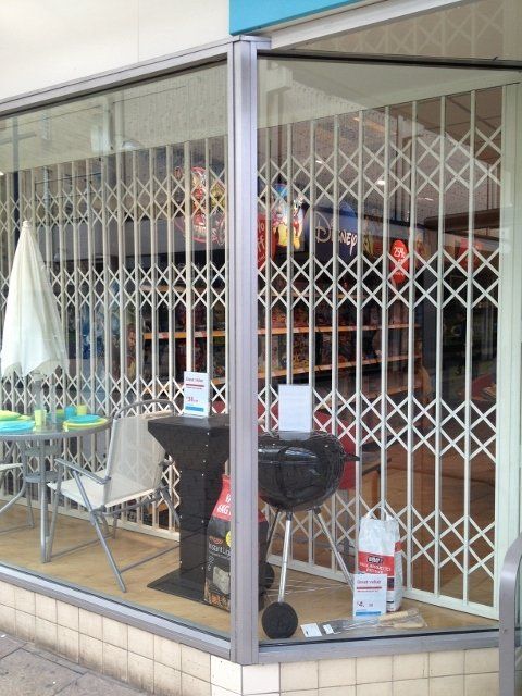 A store front with a grill in the window