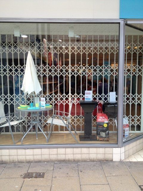 A store front with a table and chairs in the window