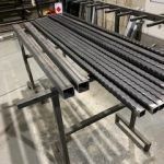 A bunch of metal pipes are sitting on top of a table.