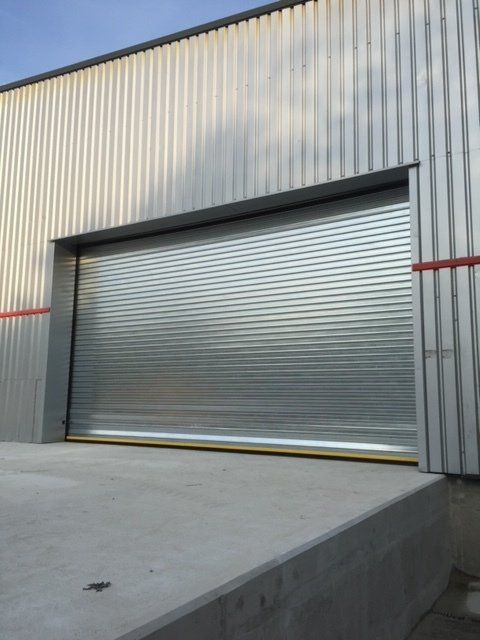 A gray building with a large garage door