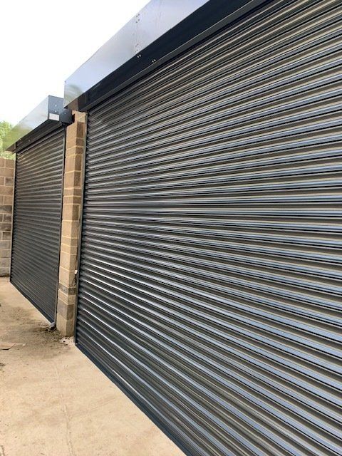 A row of black roller shutters on a building.