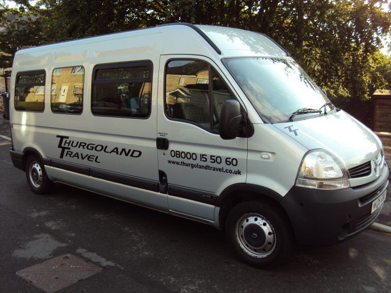 A white tourgoland travel van is parked on the side of the road