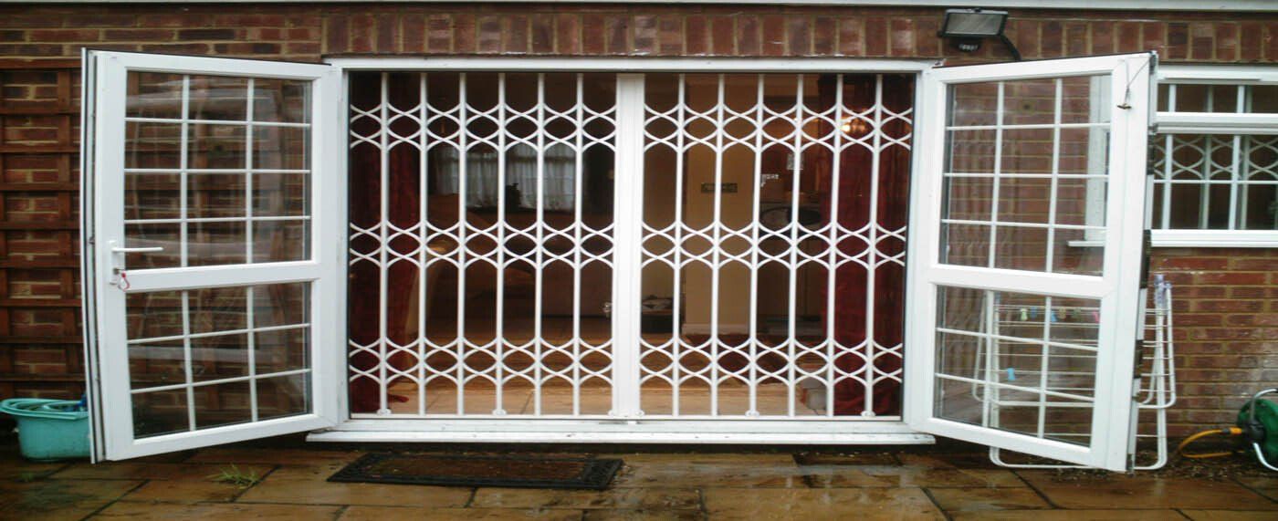 A white gate with a brick wall behind it