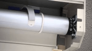 A close up of a roller shutter with a motor attached to it.