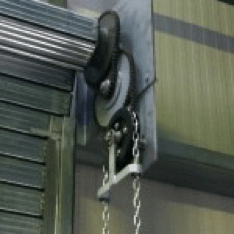 A close up of a roller door with a chain attached to it.