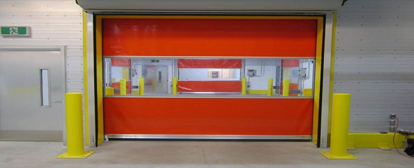 A red and yellow garage door is open in a warehouse.
