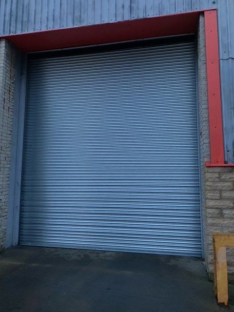 A large metal garage door with a red trim