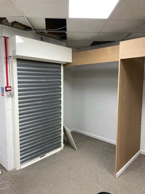 A room with a roll up door and a fire alarm