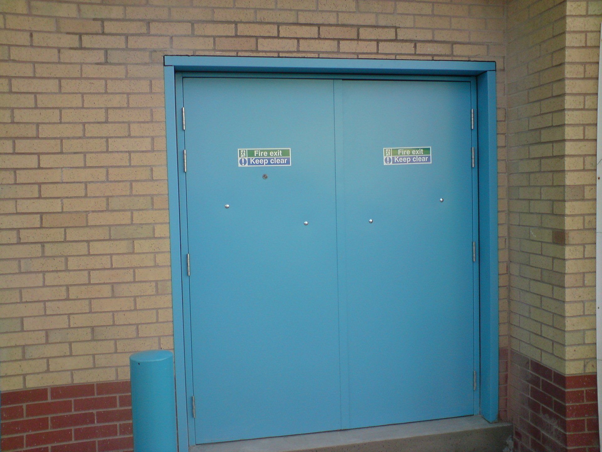 A blue door on a brick wall that says private