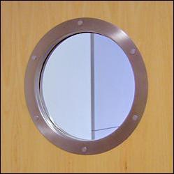 A round window on a wooden door with a stainless steel frame.