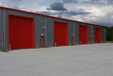 A row of red garage doors on a building