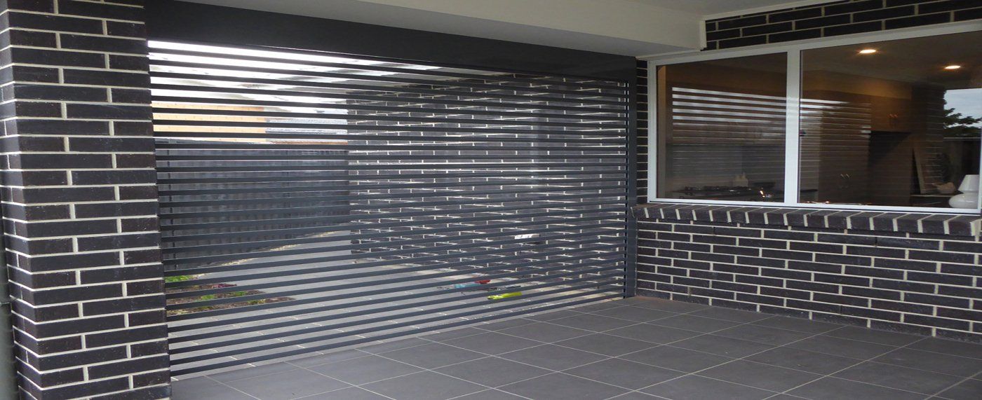 A brick wall with a sliding garage door and a window.