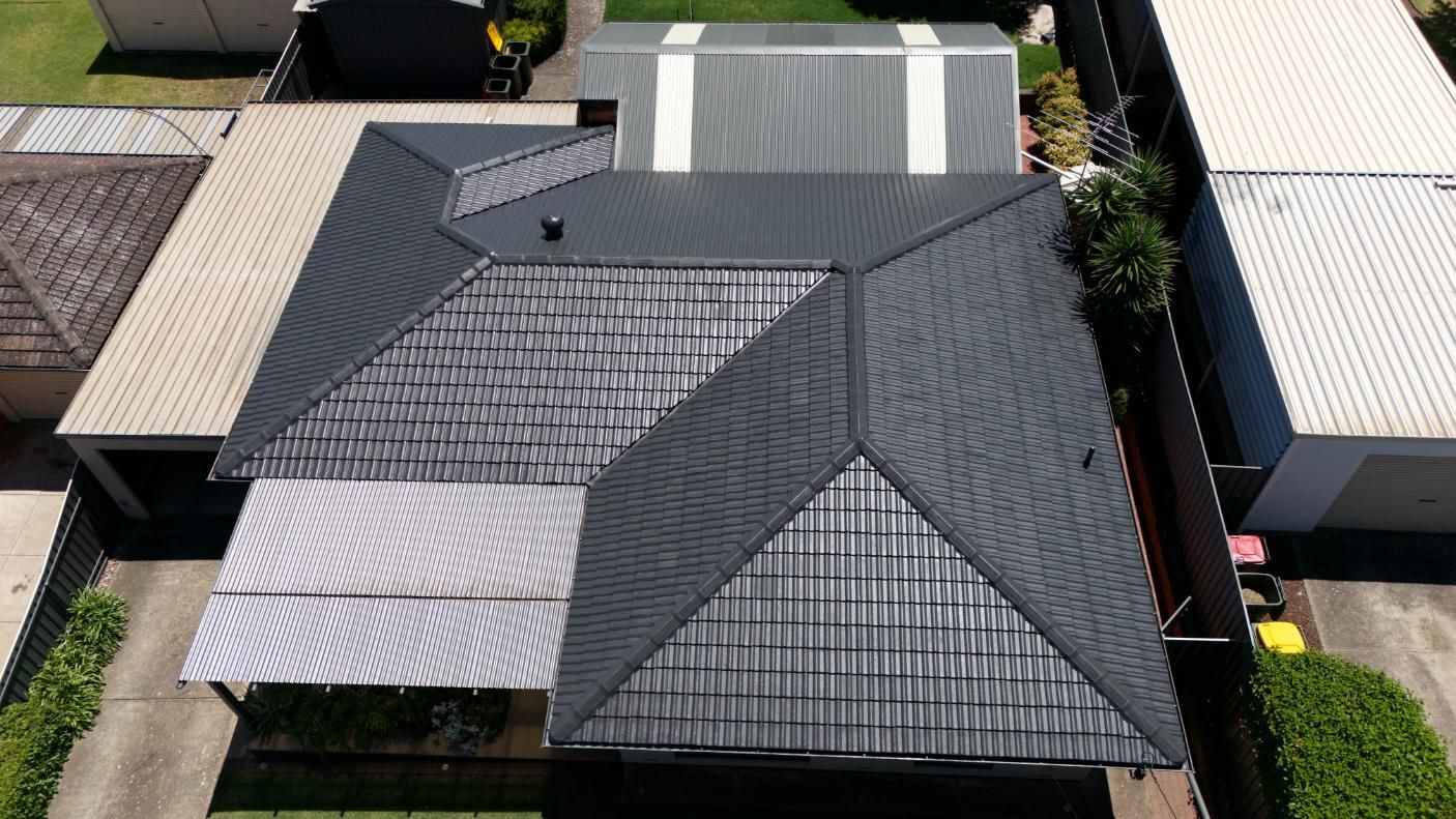 Aerial view of several houses with dark gray roofs in a residential neighborhood