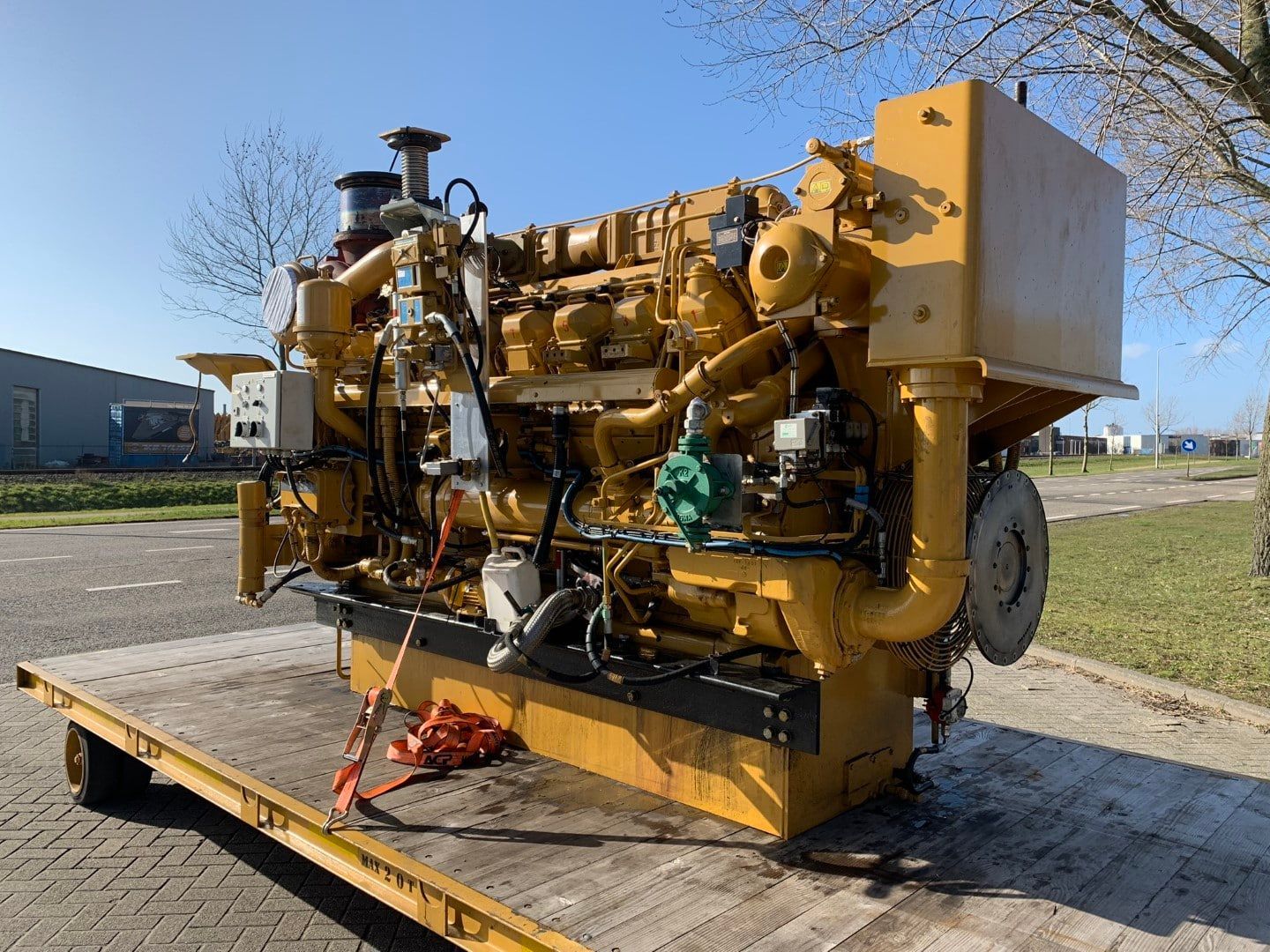 A large yellow engine is sitting on top of a trailer.