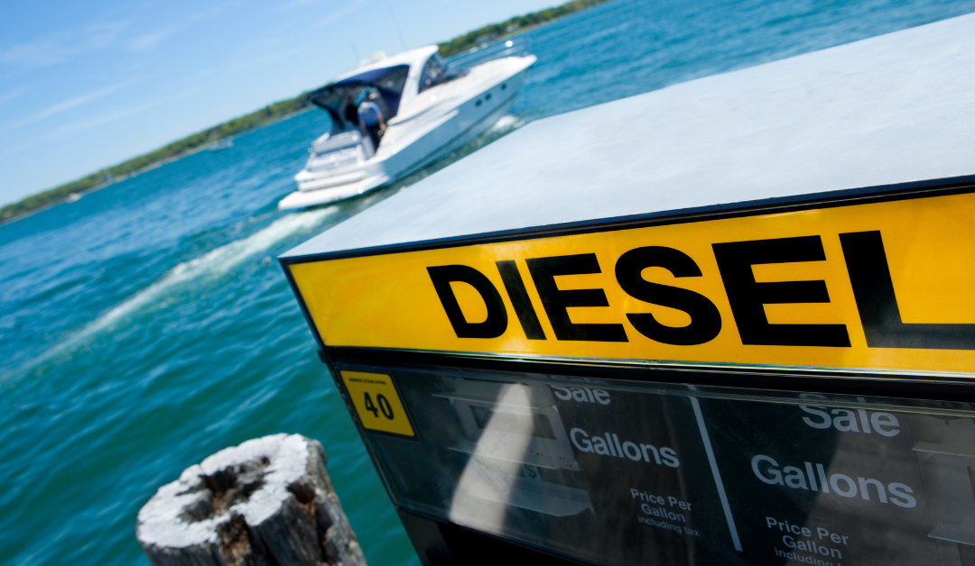 A yellow sign that says diesel is next to a boat in the water