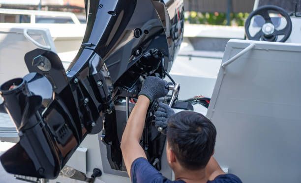 A man is working on the engine of a boat.