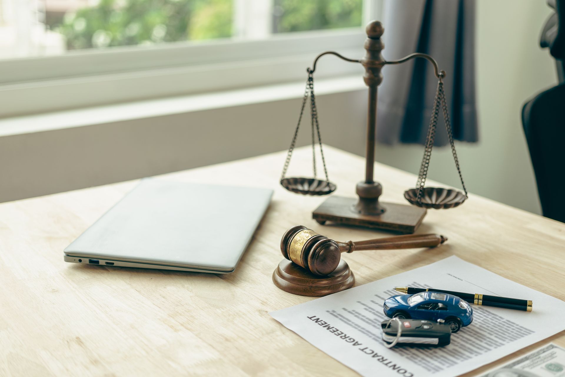 Legal desk with scales of justice, gavel, and car accident documents with a toy car and keys. Legal desk with scales of justice, gavel, and car accident documents with a toy car and keys.