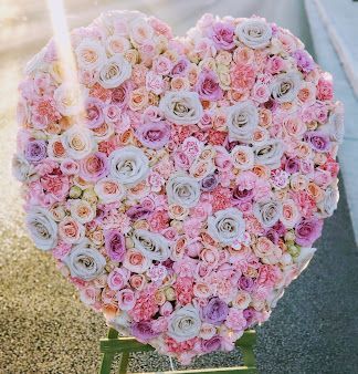 A heart shaped display of pink and purple flowers