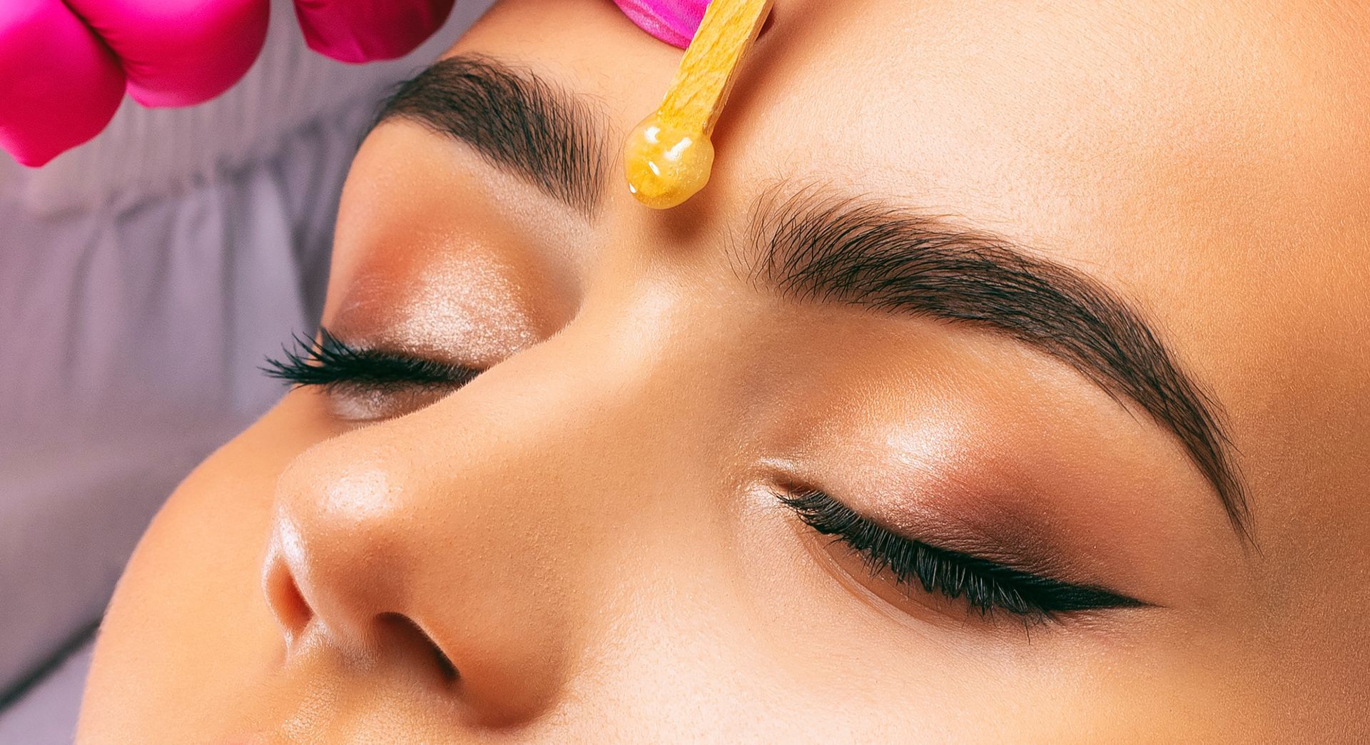 A woman is getting her eyebrows waxed in a beauty salon.