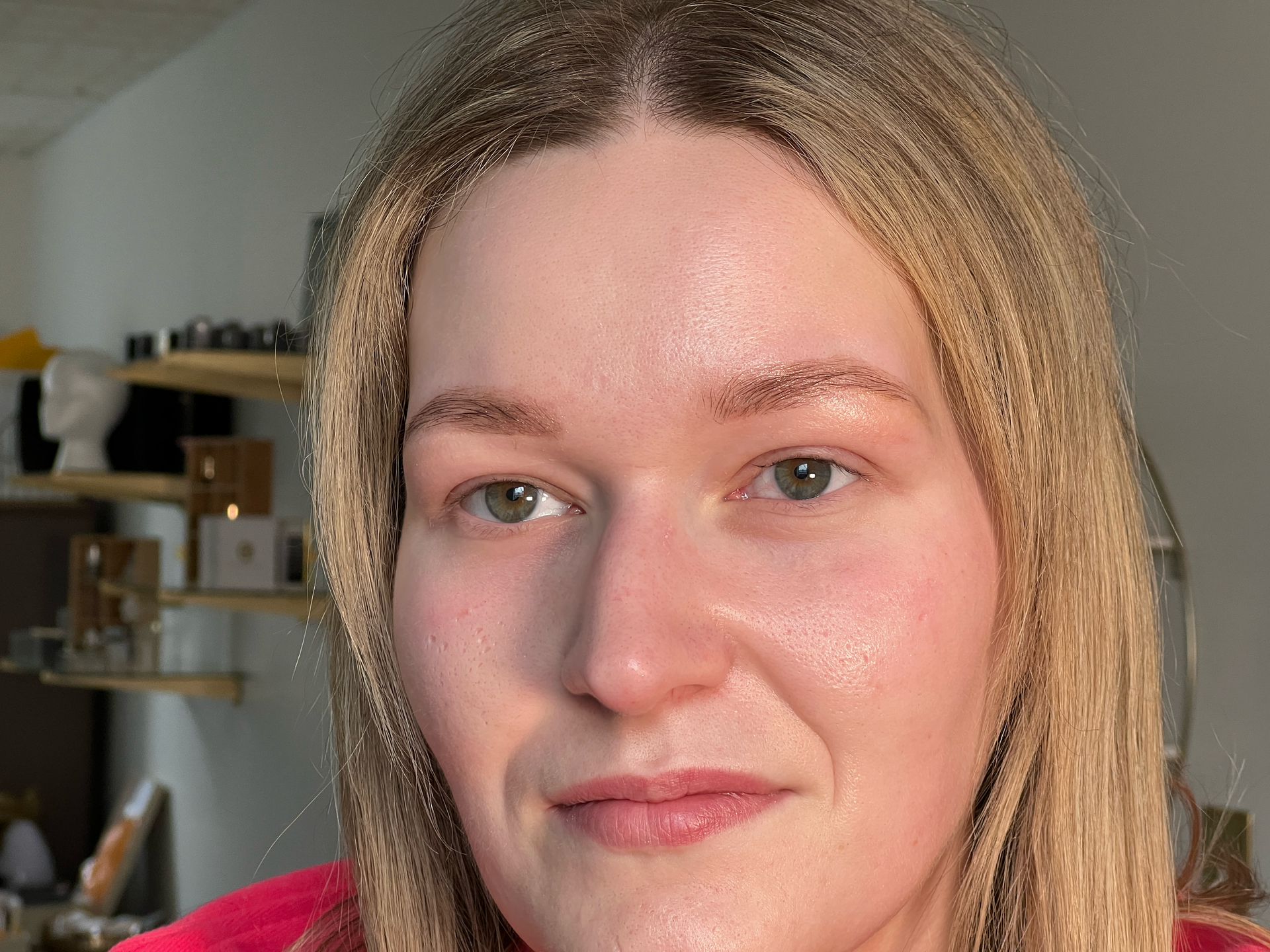 A close up of a woman 's face with a red shirt on.