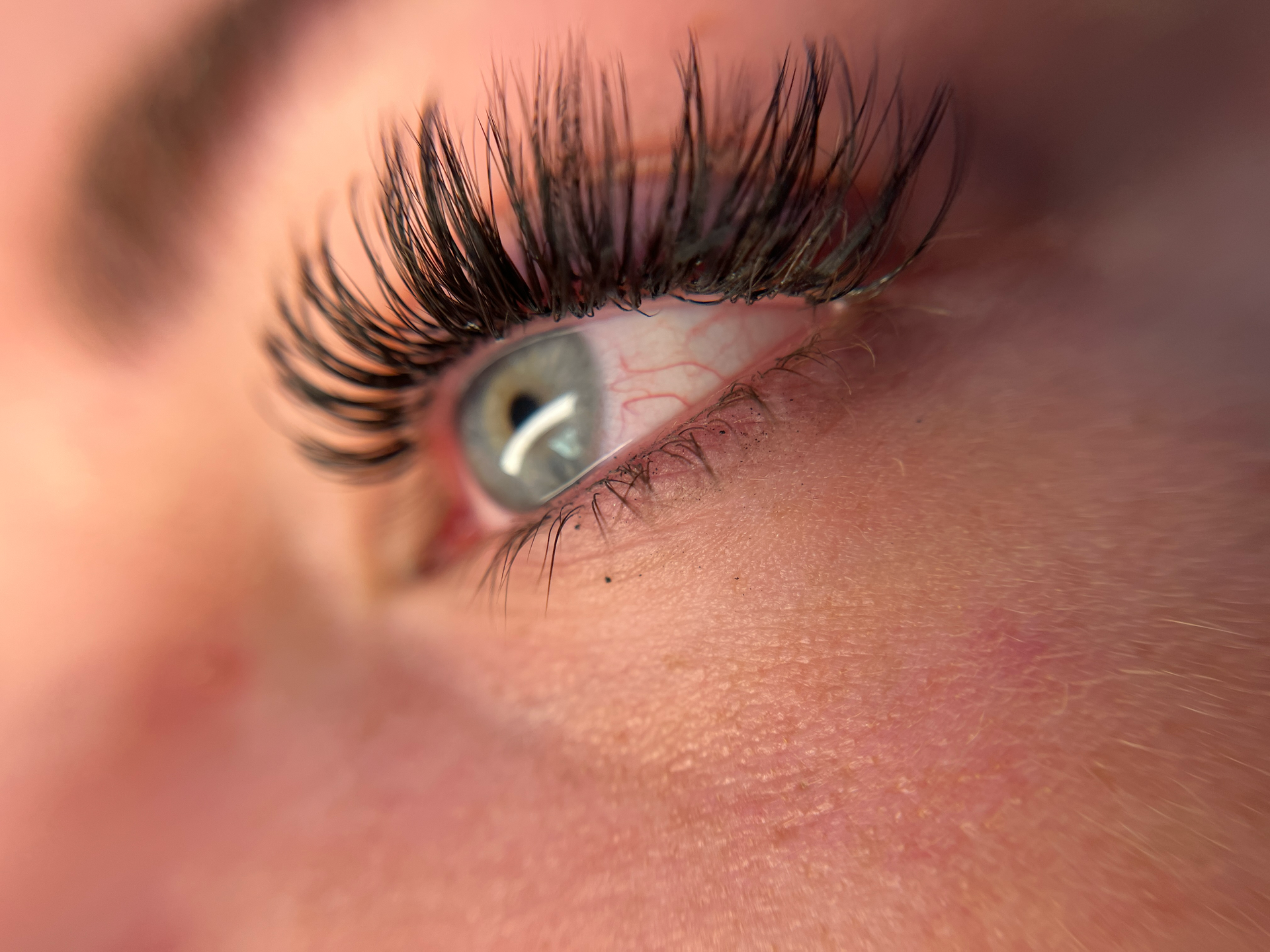 A close up of a woman 's eye with long eyelashes.