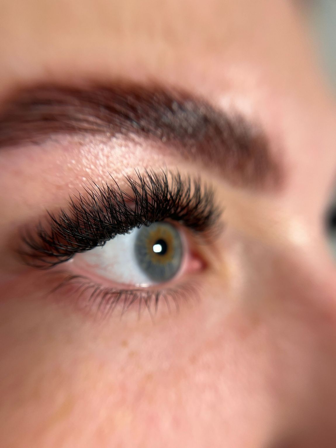 A close up of a woman 's eye with long eyelashes.