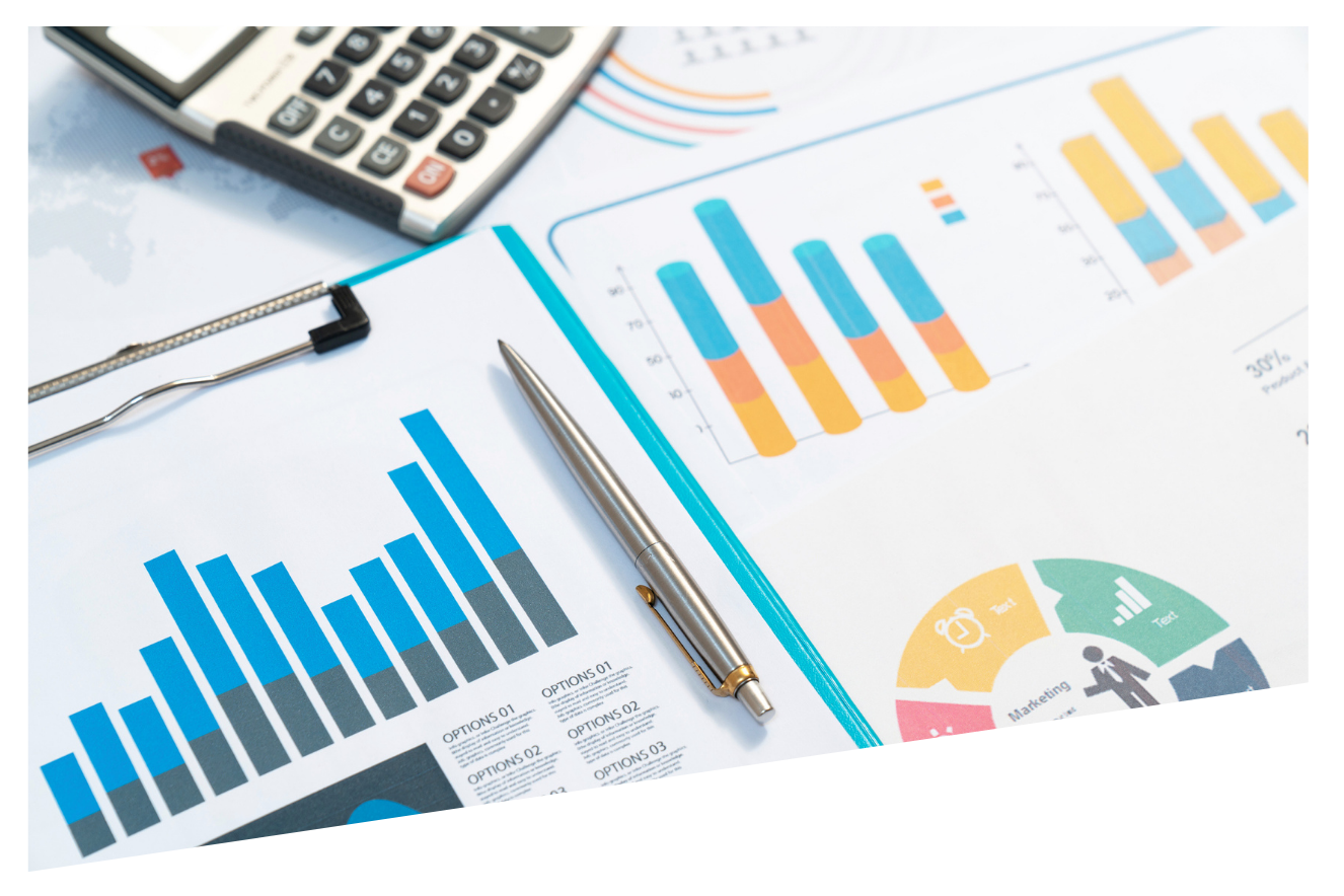 A pen is sitting on top of a clipboard next to a calculator and graphs.