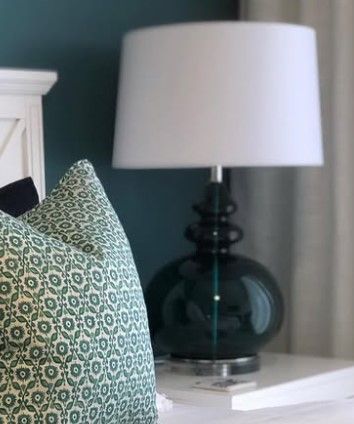 A lamp with a blue shade is sitting on a wooden table.